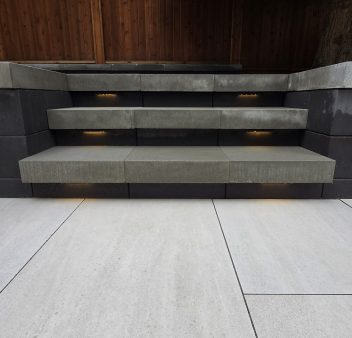 Patio steps made of concrete that lead to a tile patio